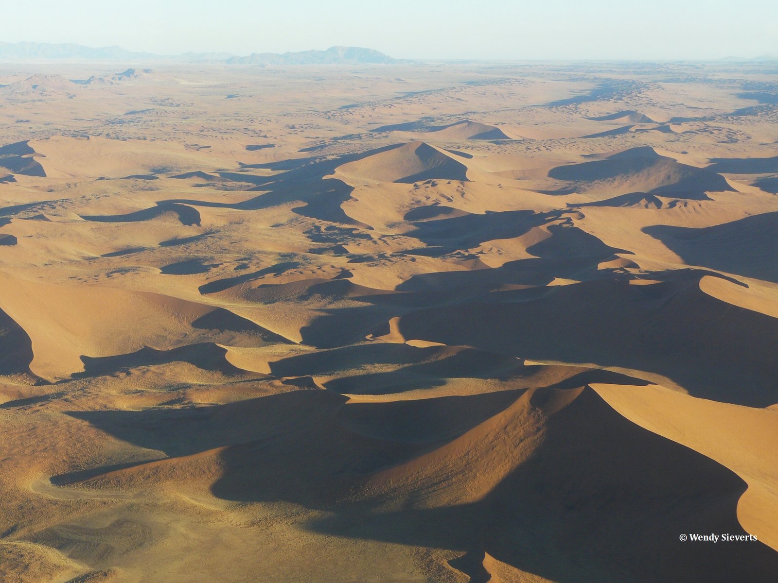 De rood en bruine zandduinen van de Sossusvlei in Namibië vanuit de lucht gefotografeerd